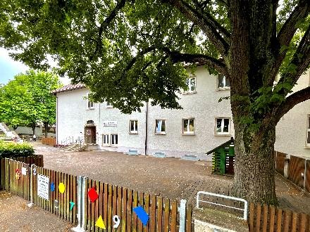 Außenansicht des Kinderhaus Bismarckstraße  mit Gebäude, Baum und Innenhof